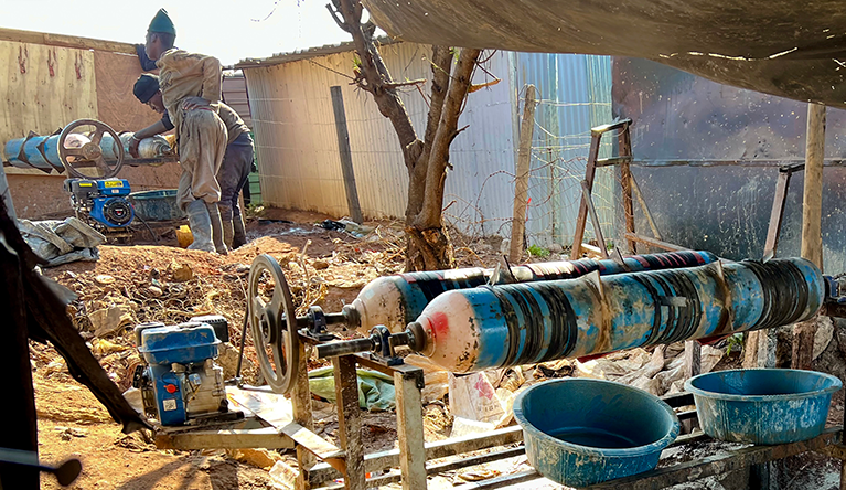 Two men tend to phendukas powered by generators at the Mandleni informal settlement near Wattville, Benoni, South Africa, on 28 August 2026. The phendukas crush gold-bearing ore into fine material before it is washed and further processed using chemicals to extract gold. Photograph: Tebogo Letsie/SA|AJP